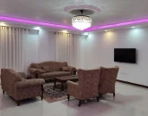 اتاق پذیرایی با مبلمان قهوه ای رنگ و کفپوش سرامیکی و تلوزیون دیواری ویلا در محمودآباد 45649